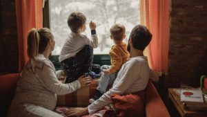 pregnant-woman-with-two-kids-and-husband-look-at-snow